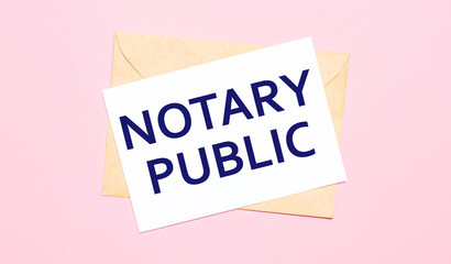 On a light pink background - a craft envelope. It has a white sheet of paper that says NOTARY PUBLIC.