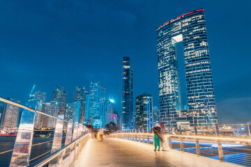 Panoramic view of footbridge with tourists leading to numerous skyscrapers with hotels and...