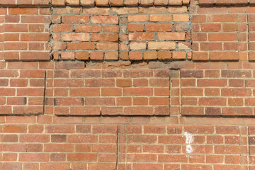 The wall of an old rural church made of orange bricks. Close-up. Curly brickwork. Texture of a brick wall of an ancient church (Ural, Russia) 