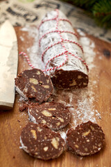 Chocolate salami on a wooden board. Christmas decor. Side view.