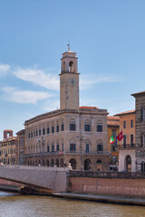 Fototapeta na wymiar The Palazzo Pretorio and its clock tower next to the Logge Dei Banchi, the Ponte Di Mezzo and the Palazzo Gambacorti in Pisa, Italy