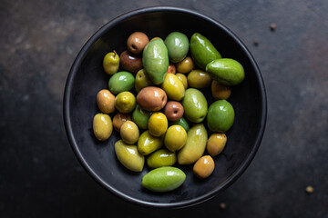 pitted olives in a plate on the table different varieties of fruits  vegan or vegetarian food keto or paleo diet snack trend meal copy space food background rustic. top view 