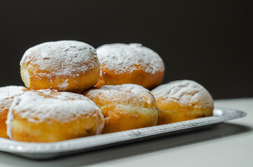 Berliner Pfannkuchen, a German donut, traditional yeast dough deep fried filled with chocolate cream and sprinkled with powdered sugar