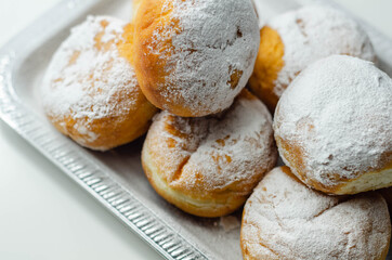 Berliner Pfannkuchen, a German donut, traditional yeast dough deep fried filled with chocolate cream and sprinkled with powdered sugar