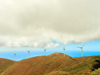 Renewable energy wind power plant with windmills on a mountain in the middle of nature