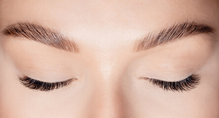 Woman eye with beauty black lashes. Eyelash extension procedure top view