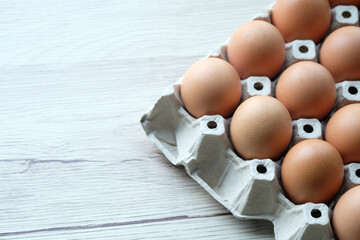 Chicken eggs in the carbon box with the wood background and copy space use as fresh ingredient for good meal