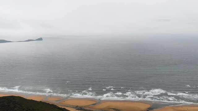 Drone Shot Flying Over The Cliff, Revealing Rhossili Beach And Rhossili Bay With Worms Head In The Background, In The Gower Peninsula, Llangennith, Wales