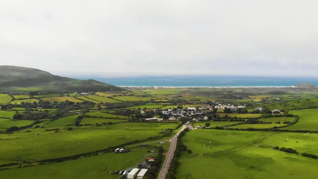 Slow Revealing Backwards Shot Of The Road Leading Into Llangennith Village, With Rhossili Beach and Rhossili Bay In The Background, In The Gower Peninsula, Llangennith, Wales