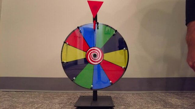 Man spinning a colorful prize wheel.
