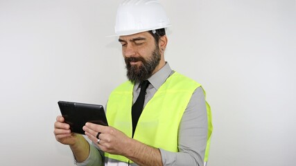 Architect wearing hardhat smiling happy, isolated on white background standing with smile on face holding tablet.