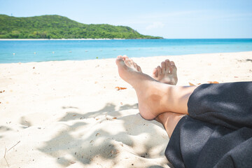 Closeup of woman's feet relaxing on a tropical beach in the sea. summer tropical concept.
