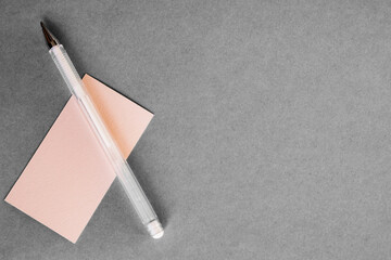 A collection of stationery on a gray background. A notebook with a pen on a gray background. Clock,...