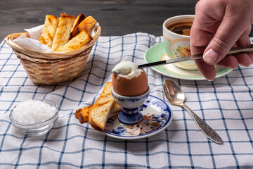 soft-boiled egg on a stand, croutons and a cup of coffee