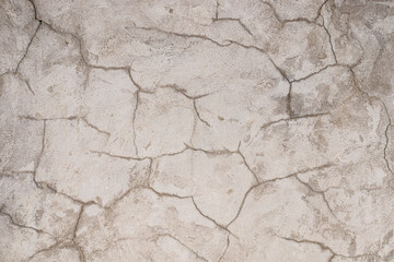 Cracked plastered cement wall as background close-up