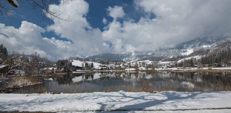 Panorama verschneiter Ort mit See.