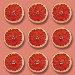 Grapefruit slices on pink background 