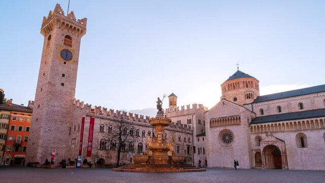 Trento, Italy. Trento roman catholic Cathedral with the fountain of Neptune during the morning. Time+lapse of morning sunlight over the square in famous touristic town in Italy