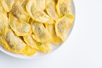 Top view of egg wrapped dumplings (also known as omelette dumplings) with pork filling on a white plate isolated on white.