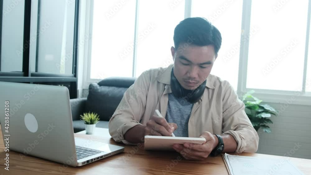 Poster web design asian man using graphics tablet pen sketching drawing drafting design work from paper int