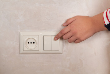  On or off light switch. Woman hand.