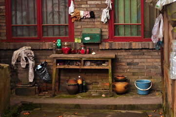 The courtyard of a traditional Chinese house with dishes and clothes hanging on ropes.