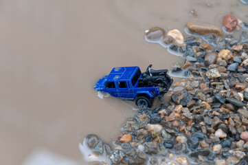 Car crosses river. Car submerged in flood water. Flood Insurance concept image. Driving through deep water