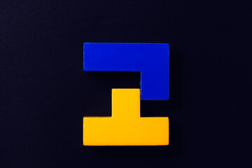 Obraz premium Blue and yellow tetris puzzles on a dark background.