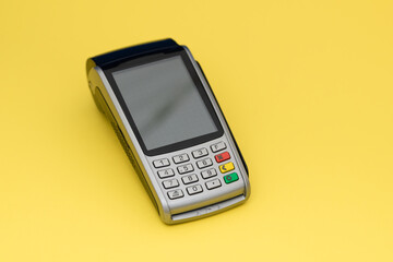 Payment terminal, compact POS terminal on yellow background top view copy space