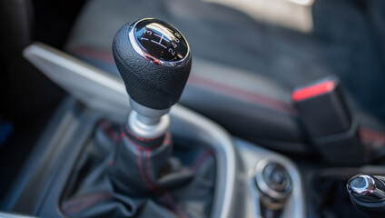 Intertior of a Suzuki motor vehicle focusing on the gear stick with untentional shallow depth of...