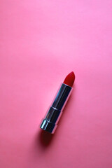 Red lipstick on bright pink background. Flat lay.