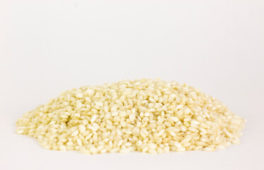 Uncooked arborio rice. Risotto rice on white background. Pile of Arborio short grain white rice isolated on white. Background of major rice varieties Arborio.