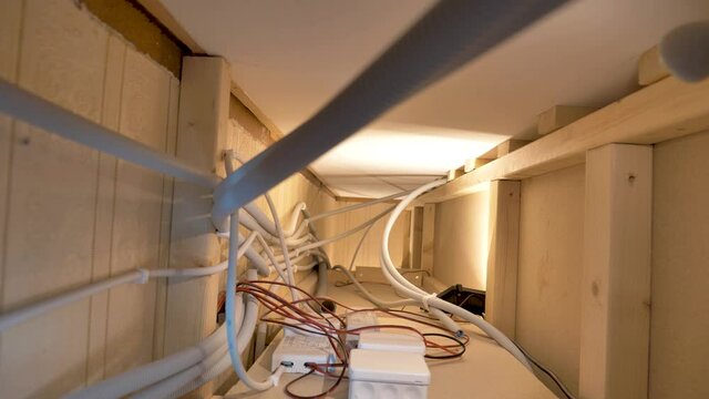Several junction boxes with electrical cables inside the inner wall. Gray Wire Loom Tubing with power cables, red-black cables go into junction box. Camera moves up into the duct.