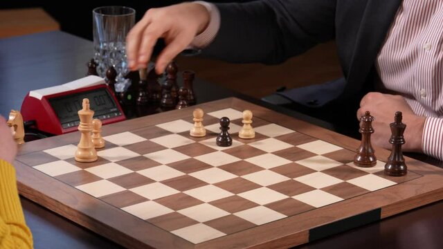 Woman outplays man in strategic chess game. Close-up high angle