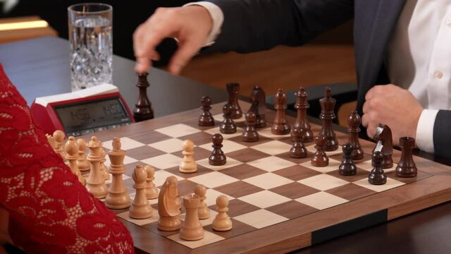Intelligent woman opening chess game with queen gambit strategic move. Closeup