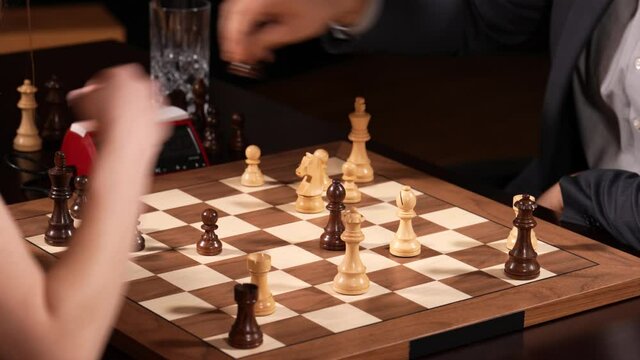 Woman attacks man in chess game match. Closeup lockdown shot