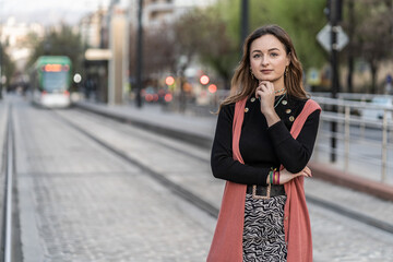 Fototapeta premium pretty young woman waiting for the arrival of the tram