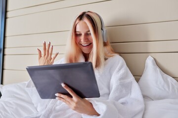 Smiling female teenager in headphones, with digital tablet