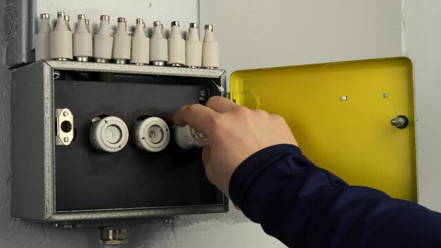 Change a fuse in old fuse box. A metallic cabinet with three older ceramic fuses. A hand unscrews a fuse. You see a close-up of the ceramic fuse. On top of the cabinet is a row of fuses.