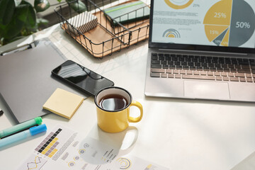 Close-up of table with laptop and cup of coffee at modern office