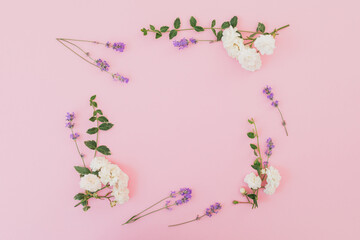 Floral frame of white roses and lavender flowers on pink background. Flat lay