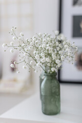 Bouquet of gypsophila in the a small green vase. Close-up