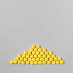 Yellow pills on a gray background.