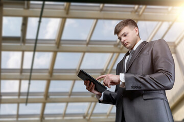 Businessman working on tablet computer in business center.