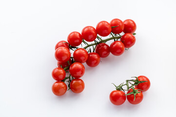 The sprig of red cherry tomatoes on a white background.