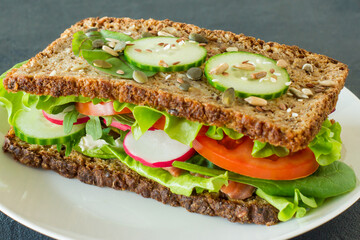 Homemade healthy wholegrain sandwiches with vegetables and smoked salmon. Tasty breakfast and healthy eating concept