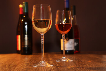 Nahaufnahme von zwei Gläsern Wein mit Weinflaschen im Hintergrund