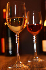 Nahaufnahme von zwei Gläsern Wein mit Weinflaschen im Hintergrund