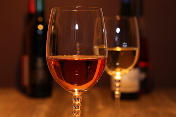 Nahaufnahme von zwei Gläsern Wein mit Weinflaschen im Hintergrund