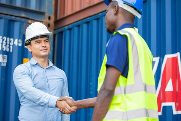 Engineer foreman handshaking with African American construction site worker. Man meeting, greeting or success work, People working for logistic export import business at container warehouse